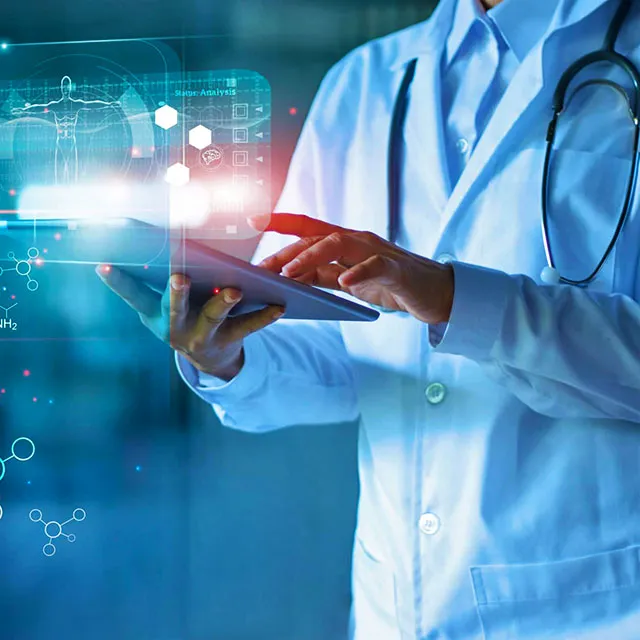 Tim medis sedang meninjau data kanker di layar komputer dengan bantuan sistem kecerdasan buatan di ruang perawatan onkologi.