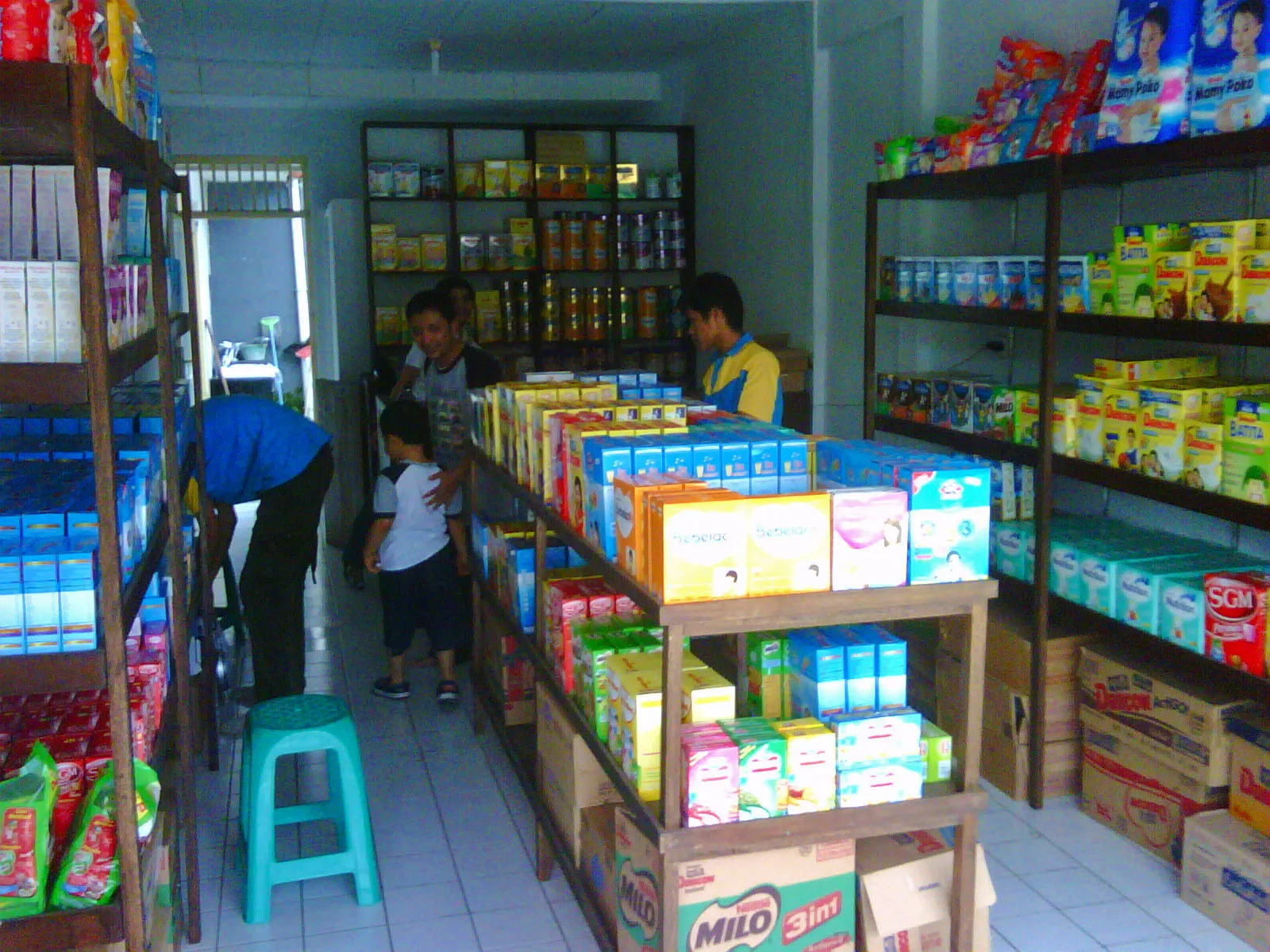 Suasana toko kelontong kecil dengan rak barang yang rapat