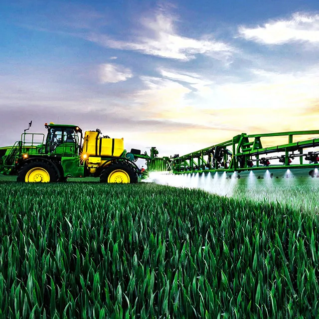 Traktor dengan sprayer modern di tengah lahan pertanian