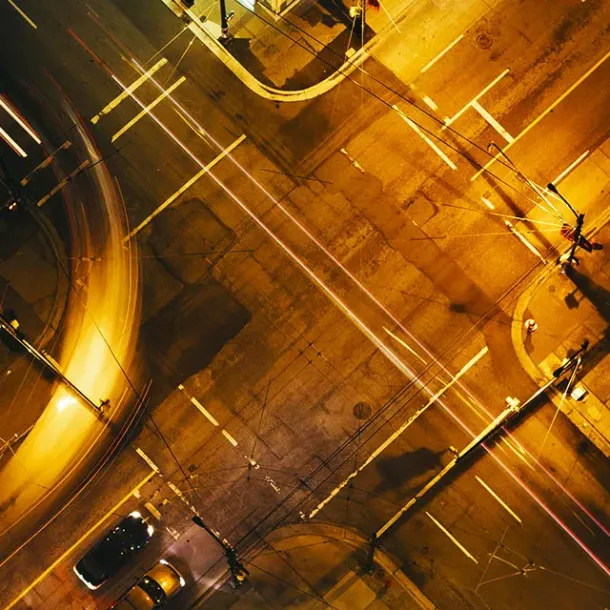 Persimpangan kota malam hari dengan jejak lampu kendaraan